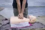 Person yder hjertemassage på en dummy