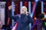 Tom Jones synger på en scene iført ternet blåt tøj