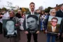 Demonstranter bærer billeder af mænd