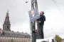 mand hænger plakat op