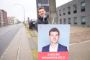 mand hænger plakat op