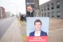 mand hænger plakat op