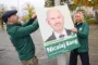 mand og kvinde hænger plakat op