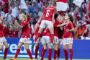 Rød og hvid-klædte kvinder jubler over en scoring