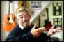 mand fægter med armene - guitarer i baggrunden