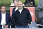 Anders Holch Povlsen i afslappet mørk jakke med hænderne i lommen på en tilskuerrække på et stadion