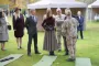 en dronning med riffel omgivet af militærpersoner
