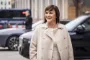 Sophie Løhde i hvidjakke foran en parkeret bil