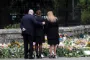tre personer ved et blomsterhav