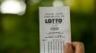 Person viser Lotto-kupon frem