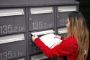 kvinde smider breve i postkasse