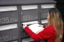 kvinde smider breve i postkasse