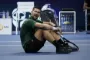 Djokovic sidder på tennisgulv