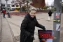 Kvinde med valgplakat ved lygtepæl