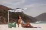 en kvinde i bikini under en parasol