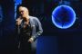 Morrissey synger på en scene med omridset af en blå måne bag sig