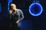 Morrissey synger på en scene med omridset af en blå måne bag sig
