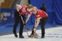 To kvindelige curlingspillere på isen