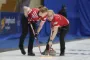 To kvindelige curlingspillere på isen