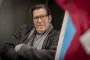 mand med korslagte arme kigger ind i kamera