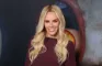Jenny McCarthy med langt blond hår, bordeaux trøje og stort tandsmil