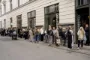 En lang række mennesker foran et vindue, der står Paustian