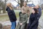 fem børn griner mens de sidder udenfor