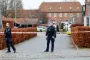 politibetjente står foran afspærringsbånd ved bygning