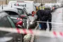 To betjente bag en politiafspærring lyser med lygte på en bils dæk