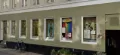 Mintgrøn husfacade med en række vinduer med plakater på.