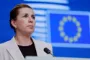 Kvinde på talerstol med EU-flag i baggrunden