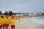 liveddere i gule trøjer og røde shorts på stranden
