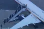 Mænd går op ad trappe til fly