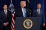 Trump står på talerstol med to mænd bag sig