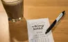 lottokupon, kuglepen og kaffekop på bord