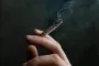 en hånd holder en cigaret