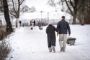 Personer går tur i sne
