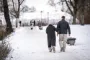 Personer går tur i sne