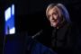 Hillary Clinton i mørk trøje på mørk baggrund