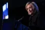 Hillary Clinton i mørk trøje på mørk baggrund