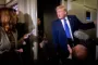Trump står i en dør og taler til journalister