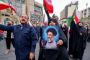 En kvinde holder et billede frem af Irans øverste leder, ayatollah Ali Khamenei, mens andre iranere vifter med iranske flag under en demonstration i den iranske hovedstad, Teheran, lørdag, for at vise opbakning til Irans styre. USA og Israel indledte natten til lørdag angreb på Iran.