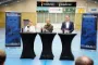 tre personer står i hal